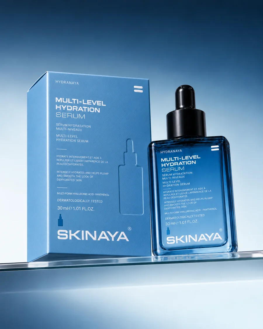 The HYDRANAYA Multi-Level Hydration Serum carton and bottle on a glass shelf in a navy-to-ice gradient
