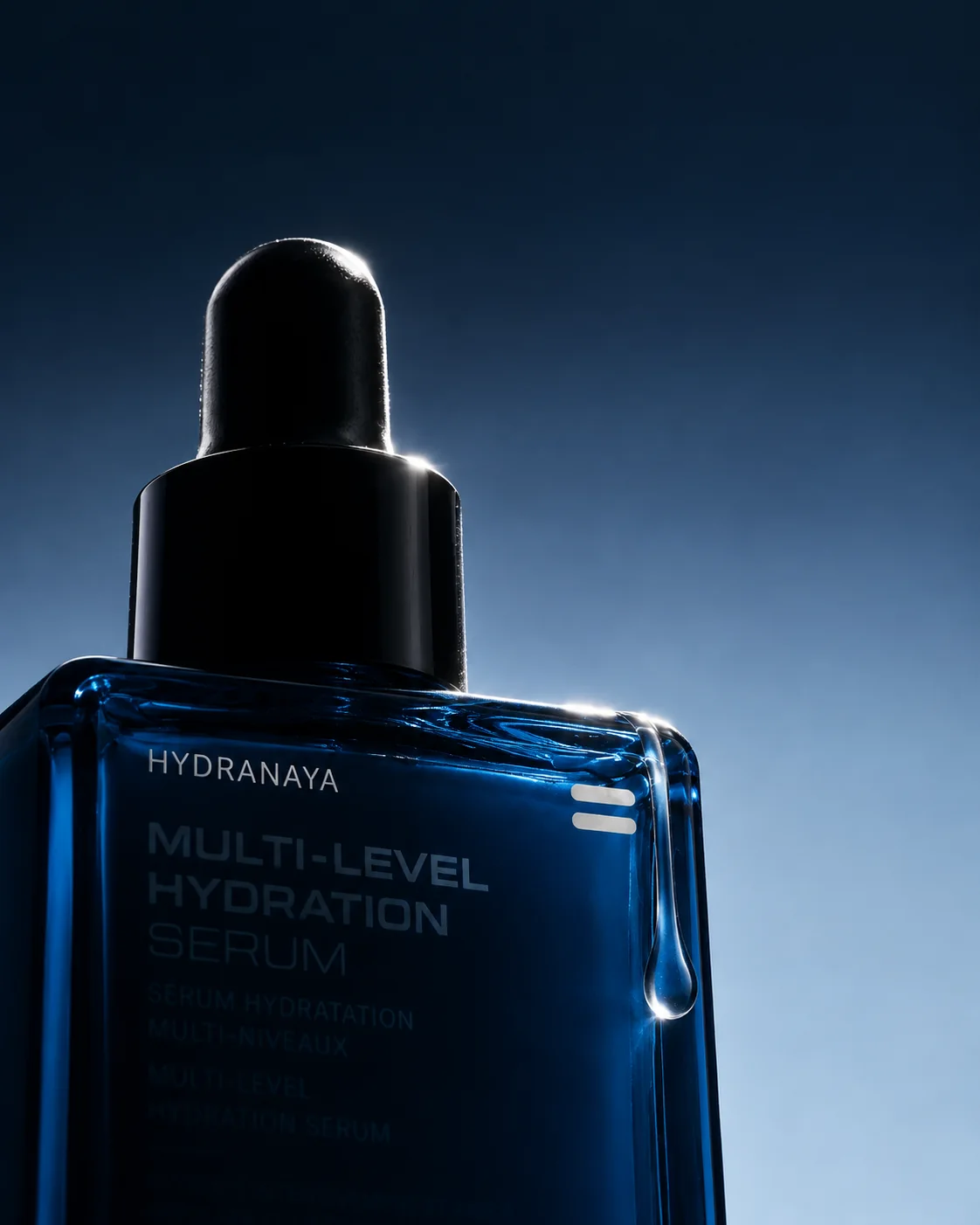 The SKINAYA HYDRANAYA serum dropper in near silhouette against a midnight-navy sky