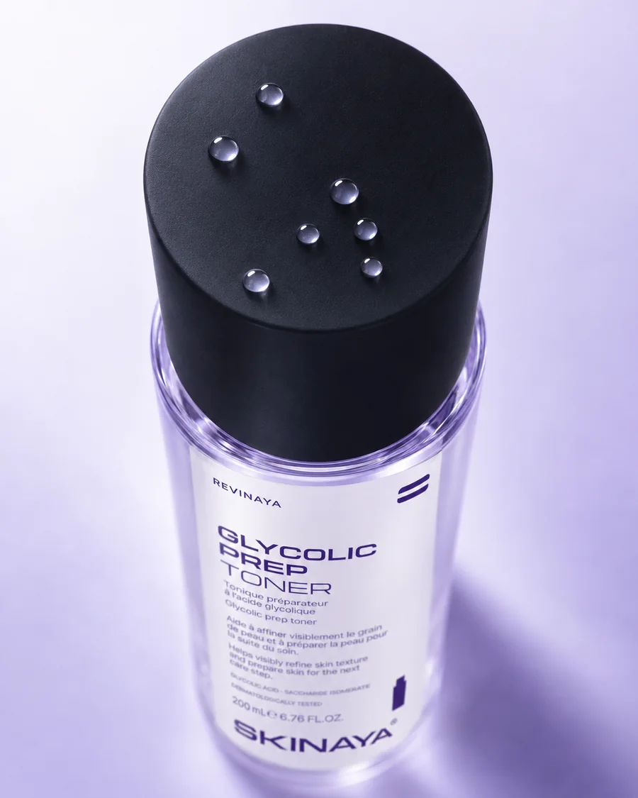 A top-down view of the REVINAYA Glycolic Prep Toner black cap with droplets